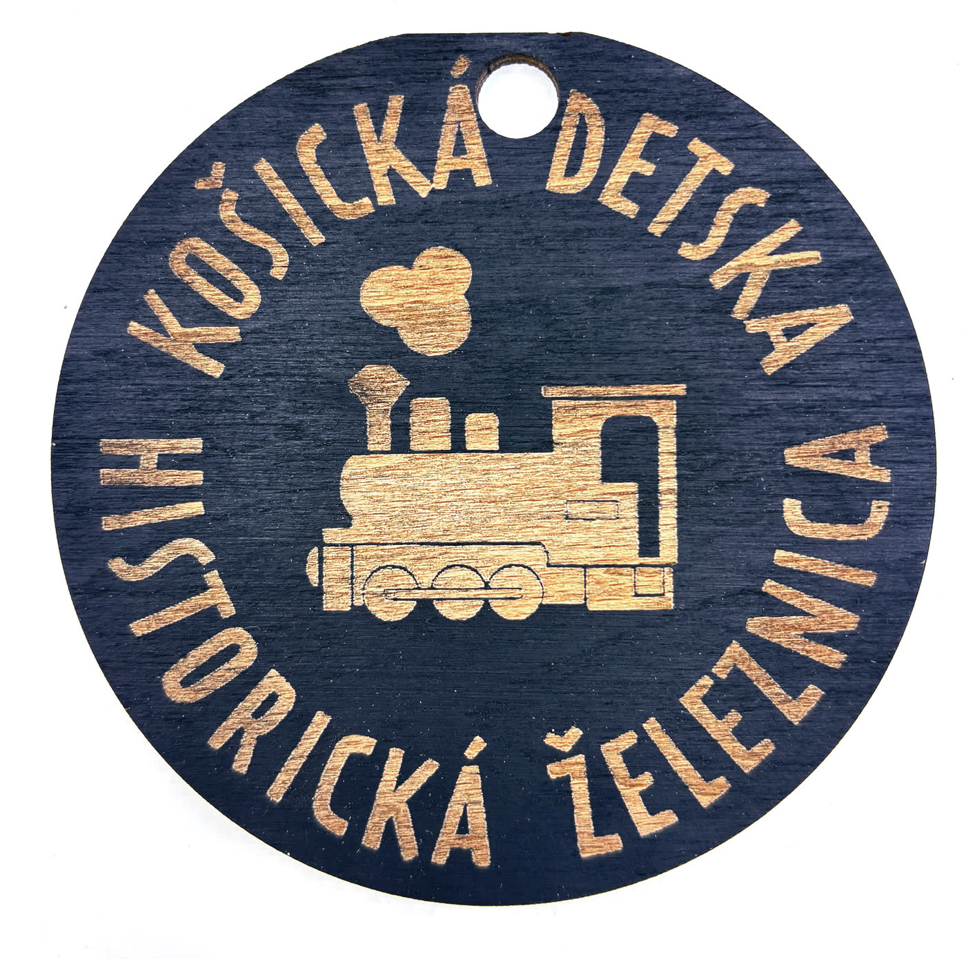 Kerek fa plakett gravírozott gőzmozdonnyal és a Kassai Történelmi Gyermekvasút nevével